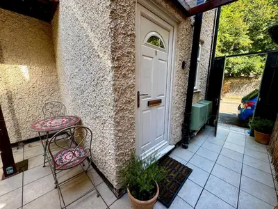 a porch with two chairs and a white door at Fig Tree Central Cambridge Apartment Walk to Colleges & River Cam in Cambridge