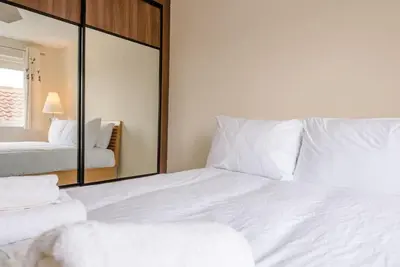 a bedroom with a large white bed and a mirror at Grove Farm Bungalow and Annexe, Dallinghoo in Woodbridge
