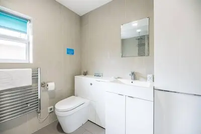 a bathroom with a toilet and a sink and a mirror at Grove Farm Bungalow and Annexe, Dallinghoo in Woodbridge