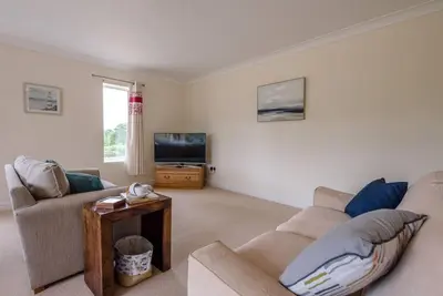 a living room with two couches and a tv at Grove Farm Bungalow and Annexe, Dallinghoo in Woodbridge