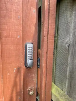 a wooden door with a remote control on it at Ferncroft Garden Studio in Histon