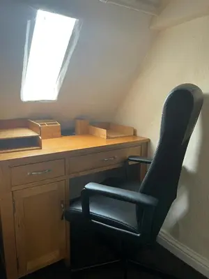 a chair sitting in front of a desk with a window at Kings head Inn in Stutton