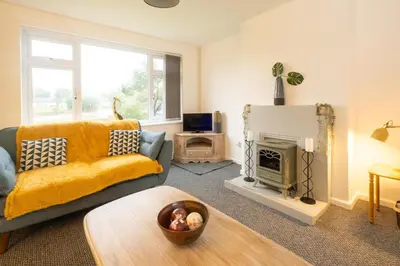 a living room with a couch and a fireplace at Hollybobs in Leiston