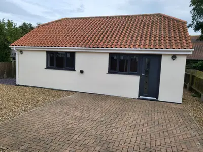 a white house with a red roof and a brick driveway at The Annex in Felixstowe