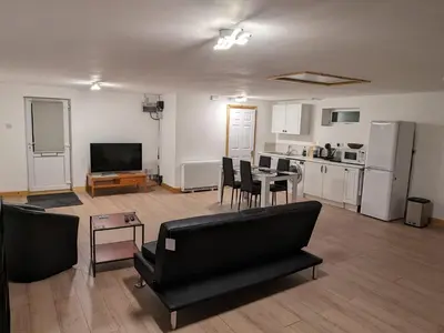 a living room with a couch and a table and a kitchen at The Annex in Felixstowe