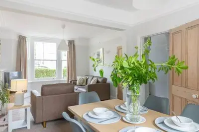 a living room with a table with plates on it at Victorian 2 Bedroom Home near the river Cam in Cambridge