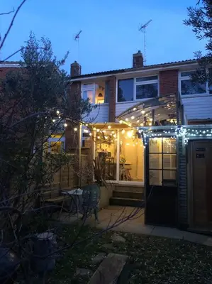 a house with christmas lights on the front of it at Cosy hideaway with garden sauna in Cambridge in Cambridge