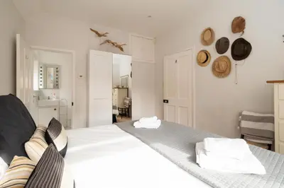 a bedroom with a large white bed with towels on it at Pantiles in Aldeburgh