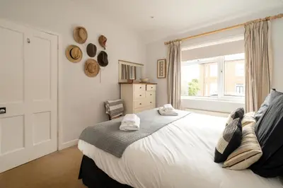a bedroom with a large white bed with a window at Pantiles in Aldeburgh