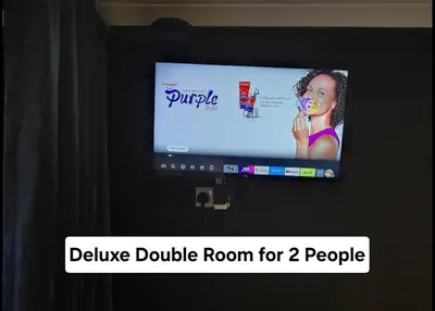 a television screen with a picture of a woman brushing her teeth at Luxury on a Budget Chelmsford - B&B ROOM in a quiet family home in Chelmsford