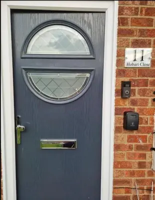 a blue door with a window on a brick building at Luxury on a Budget Chelmsford - B&B ROOM in a quiet family home in Chelmsford