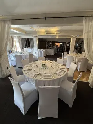 a dining room with white tables and white chairs at The Blue Anchor Feering in Colchester