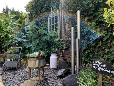 a garden with a sign and some plants at The Blue Anchor Feering in Colchester