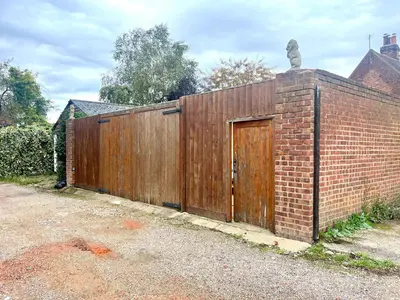 a wooden fence with a wooden door on a brick wall at Duchess Apt 1 Serviced 3BR Apartment in Colchester Perfect for Contractors,Temporary Housing, Relocations,Free Wifi, Secure Parking in Colchester