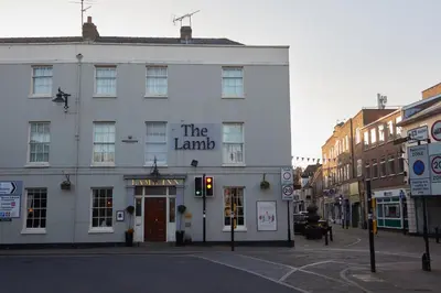 a large white building on a street with a traffic light at Lamb Hotel by Greene King Inns in Ely