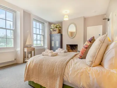 a bedroom with a large bed and a fireplace at Abbey Barn Farmhouse in Marham
