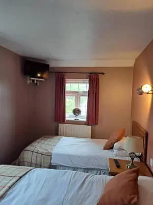 a hotel room with two beds and a window at The Prince of Wales in Huntingdon