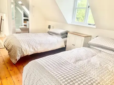 a bedroom with two beds and a window at Delightful Ely house Bright and warm with cathedral view in Ely