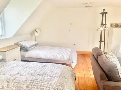a bedroom with two beds and a couch in it at Delightful Ely house Bright and warm with cathedral view in Ely