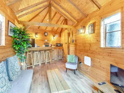 a living room with a couch and a kitchen in a cabin at Bear House- Uk45704 in Brinkley