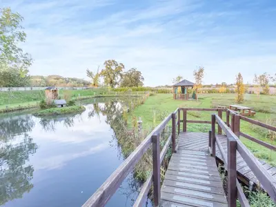 a wooden bridge over a river with a gazebo at Beavers- Uk45706 in Cambridge