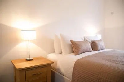 a bedroom with a bed with a lamp on a night stand at Citystay Living - The Vie in Cambridge