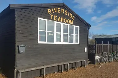 a black building with a sign on the side of it at Marshlands House, Sleeps 16 - Country barn with hot tub in Woodbridge