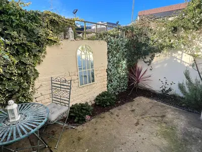 a table and a chair next to a building at Central Brentwood House in Brentwood