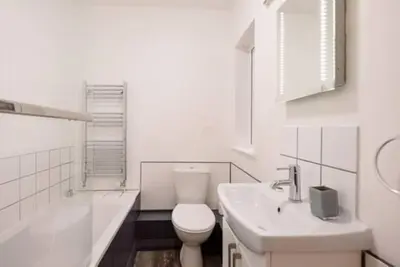 a white bathroom with a toilet and a sink at 1 & 2 Abbey Mews, Leiston in Leiston