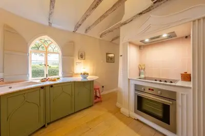 a kitchen with green cabinets and a window at A fairy-tale luxurious cottage - The Tea Caddy in Colchester