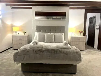 a bedroom with a large bed with two night stands at Duchess Apt 2 Modern 3Bedroom Apartment in Colchester Ideal for Long Stays, Relocations, Contractors, Secure Parking, WIFI in Colchester