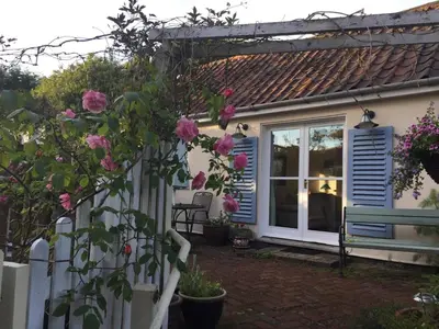a house with blue shutters and a white fence at Mulleys Cottage (Bed and Breakfast) in Westleton