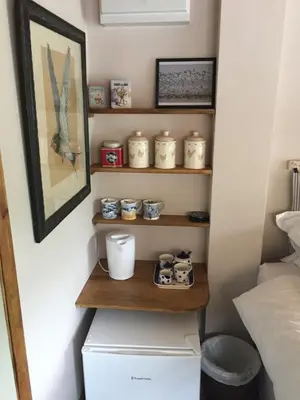 a room with a shelf next to a bed at Mulleys Cottage (Bed and Breakfast) in Westleton