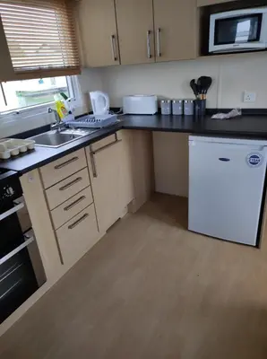 a kitchen with a white refrigerator and a sink at Dovercourt holiday park swift johnson low road harwich essex co12 3TZ in Parkeston