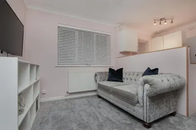 a living room with a couch and a television at Hurrell House in Boreham