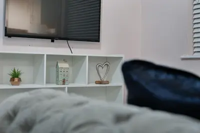 a white shelf with a tv and a heart on it at Hurrell House in Boreham