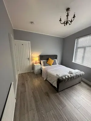 a bedroom with a bed and a chandelier at Herbies Stay in Southend-on-Sea