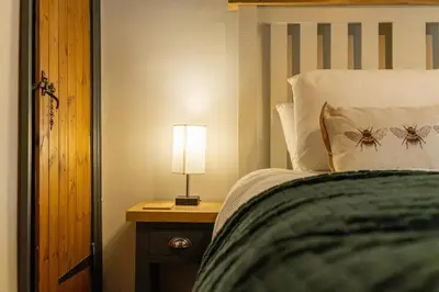 a bedroom with a bed with a lamp on a table at Charming 2 bedroom property in Bury Saint Edmunds
