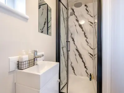 a bathroom with a sink and a shower at Rose Cottage in Peldon