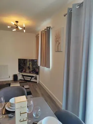 a dining room with a table with wine glasses on it at 2 bedroom en-suite apartment in Basildon, Essex (Enjoy the simple things in life) in Laindon