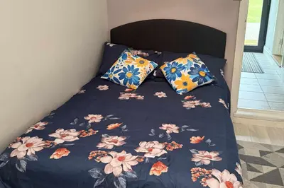a bed with a blue comforter with flowers on it at 1 Bed Sleeps 2 with Private Garden in Harlow