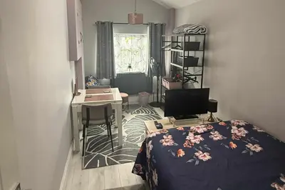 a bedroom with a bed and a desk with a computer at 1 Bed Sleeps 2 with Private Garden in Harlow