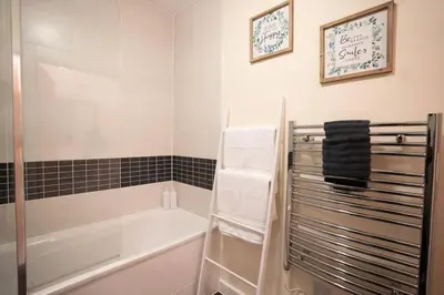 a bathroom with a bath tub and a shower at Cosy 2 Bedroom flat in Stevenage in Stevenage