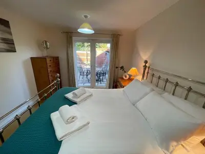 a bedroom with a bed with two towels on it at Cosy Country Hideaway opposite Three Horseshoes Pub in Madingley village in Madingley