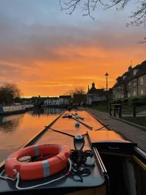 a boat on a river with an orange raft at Cambridge Narrowboats - Beautiful Narrowboat Glyndwr in Cambridge