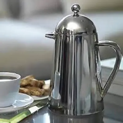 a silver coffee pot sitting next to a cup of coffee at Cambridge Narrowboats - Beautiful New Moon Narrowboat in Cambridge