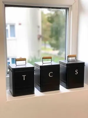 three black boxes sitting on a window sill at Cozy studio near train station in Cambridge