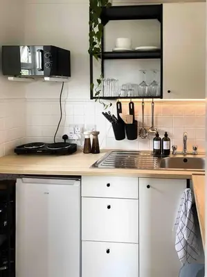 a kitchen with white cabinets and a counter top at Cozy studio near train station in Cambridge