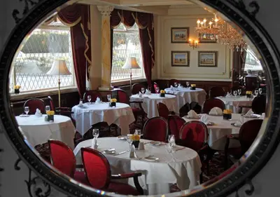 a mirror reflecting a dining room with tables and chairs at The Orwell Hotel in Felixstowe