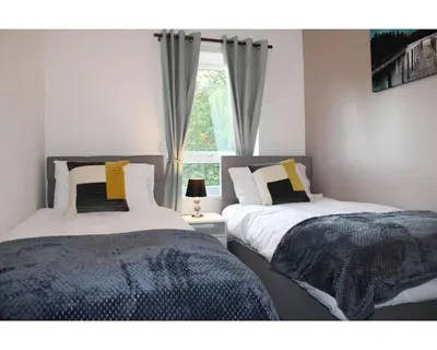 two beds in a bedroom with a window at A Comfortable Nest for Contractors or Families - sleeps 8 in Chesterton